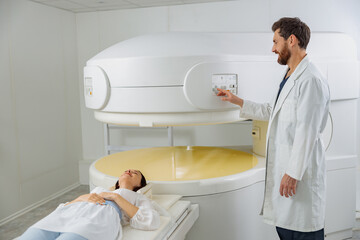 Wall Mural - Radiologist controls MRI or CT or PET Scan with female patient undergoing procedure