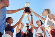 © Jade Maas/peopleimages.com - A diverse team of athletes celebrating a victory with a golden trophy and looking excited. A fit and happy team of professional athletes rejoicing after winning an award at an athletic sports event