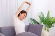 © snowing12 - Lifestyle in living room concept, Asian woman sitting on couch to stretching for relaxation