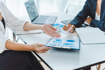 Two young Asian business female people explaining a list of collaboration using document and taking notes at the office.