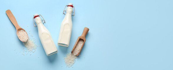 Bottles of rice milk on blue background with space for text