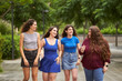 © Retamosa - Group of friends talking while walking through a park when it is starting to rain, concept friendship
