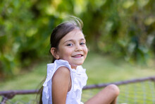 Little Girl Smiling Looking At Camera Over Shoulder