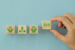 Leinwandbild Motiv ESG concept of environmental, social, and governance. Sustainable corporation development. Businessman Hand arranging wood block with text ESG with other ESG icons on blue background. Copy space.