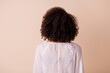 Photo of stunning curly wavy lady wear white top standing back isolated beige color background