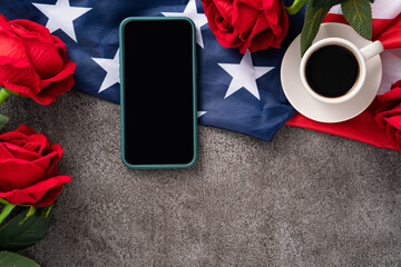 Wall Mural - Concept of Independence day or Memorial day with smart phone and coffee. Flag over dark gray table background.