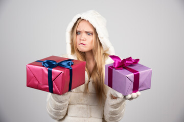 Blonde woman angrily looking at gift boxes