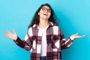 Wall Mural - Teenager Russian girl isolated on blue background smiling a lot