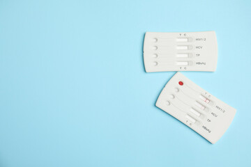 two disposable express hepatitis tests on light blue background, flat lay. space for text