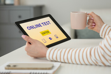 Wall Mural - Woman taking online test on tablet at desk indoors, closeup