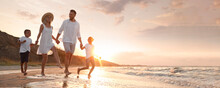 Happy Family Running On Sandy Beach Near Sea At Sunset, Space For Text. Banner Design