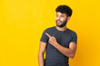 © luismolinero - Young Moroccan man isolated on yellow background surprised and pointing side