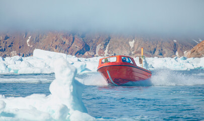 Wall Mural - fast moving motorboat trying to get out of the ice - stranded icebergs in the fog at the mouth of th