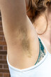 Natural unshaved hairy armpits of a body positive young woman.
