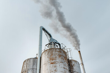 Chemical factory,smoke stack,CO2 greenhouse gas emissions coming from the smoking chimney pipe.Cloudy blue sky background.Copy space.