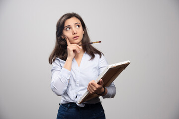 Wall Mural - Brunette painter thinking about something on gray background