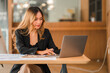 © ArLawKa - Freelance young Asian businesswoman working on laptop computer in modern office. make an account analysis report real estate investment information Accounting concepts, financial systems and taxes.