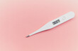 Digital white thermometer with a normal temperature of 36 degrees centigrade on a pink background in the concept of control over health and new emerging viruses for women who are in advanced gestation