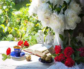 Wall Mural - Bible and a bouquet of peonies on a table in the garden