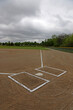 A wide angle shot of an unoccupied baseball field on a cloudy day..