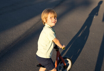 Little boy on a bicycle in the summer park