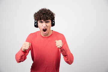 Wall Mural - Curly young man listening to song and screaming