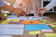 © aksonsat - Close up of hands working and brainstorming on paperworks about business financial and marketing.