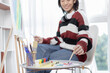 © Puwasit Inyavileart - Female artist painting on canvas, Artist studio interior, Draw with watercolor, Drawing supplies , Painting and creativity, Use a brush to draw a pattern by stripes, Artwork, Using Paint Brush.