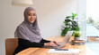 © Prathankarnpap - Elegant Muslim woman wearing hijab using computer laptop in bright modern office