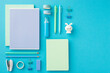 Back to school concept. Top view photo of ordered stationery diaries adhesive tape binder clips pens pencils eraser mini stapler correction pen and bunny shaped sharpener on isolated blue background