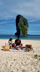 Wall Mural - In Koh Poda Krabi Thailand, an Asian woman and European man are having a picnic on the tropical beach of Koh Poda Island Krabi Thailand. 