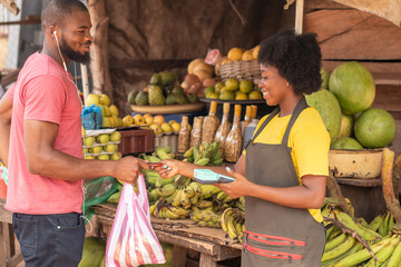 man in market paying a woman with his credit card