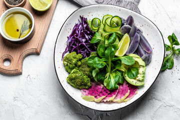 Wall Mural - vegan salad with sweet potatoes, broccoli, avocado, purple cabbage, cucumber, watermelon radish and almonds. Clean eating, dieting food concept. top view.