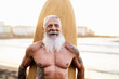 © Alessandro Biascioli - Senior fit man having fun surfing on tropical beach - Elderly healthy people lifestyle and extreme sport concept