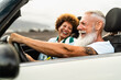 © Alessandro Biascioli - Happy senior couple having fun driving on new convertible car - Travel people lifestyle concept