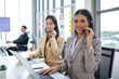 © todja - female operator agent with headsets and her team working in a call center customer service office. Asian employee woman working with a headset, Customer support.