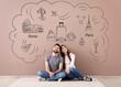 © Pixel-Shot - Young couple dreaming about their new journey near color wall in room