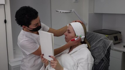 Wall Mural - Drawing lines on the patient's face with a marker, before the facelift procedure with threads