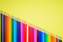 Many Different Colored Pencils On A Yellow Background. Place Your Text