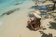 Mujer con sombrero y bikini sentada con las piernas cruzadas frente a la playa de isla en el mar caribe de Cartagena Colombia