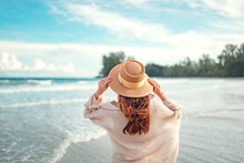Summer Beach Vacation Concept, Young Woman With Hat Relaxing With Her Arms Raised To Her Head Enjoying Looking View Of Beach Ocean On Hot Summer Day, Copy Space.