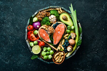 Food Banner. Healthy Foods Low In Carbohydrates. Food For Heart Health: Salmon, Avocados, Blueberries, Broccoli, Nuts And Mushrooms. On A Black Stone Background. Top View.