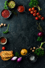 Wall Mural - Black stone cooking background. Spices and vegetables. Top view. Free space for your text.