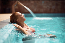 Smiling Woman With Eyes Closed Relaxing In Water At Swimming  Pool On Summer Day.