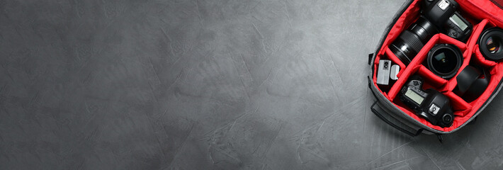 Wall Mural - professional photography equipment in backpack on grey stone table, top view with space for text. ba