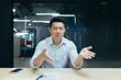 © Liubomir - Angry asian businessman talking on video call online meeting, looking at web camera, gesticulating angrily with hands, man at work in office