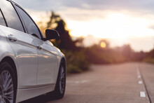 Behind A Beautiful White Car Parked On A Road With Beautiful Sunsets. With Space For Text.