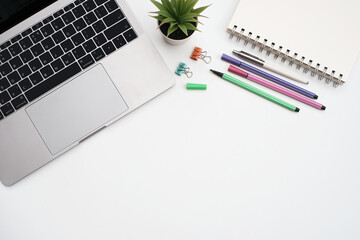 Wall Mural - Blank white notepad on laptop computer with stationery on white table desk background with copy space,Flat lay, work space, minimal work 