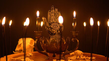 Magic And Occult Attributes On The Table, Pagan Magic Symbols Background. Blowing Black Witchcraft Candles. Spiritual Mood And Witch Craft With Mystic Fantasy Background And Smoke.