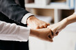 © kamiphotos - Three people put their fists together, businessmen joint venture start up companies, they are young entrepreneurs start up companies. up together to manage a plan to make the company profitable.